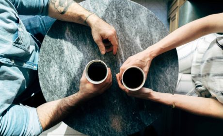 Two people at table with coffee cups to represent informal mentoring