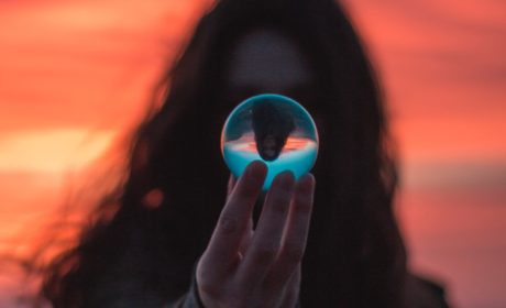 a woman looking into a reflective glass ball to represent looking into the future