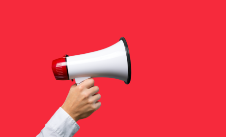 hand with megaphone on a red background